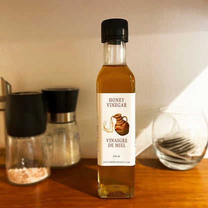 Healthy organic honey vinegar in a clear glass bottle, highlighting its golden hue.